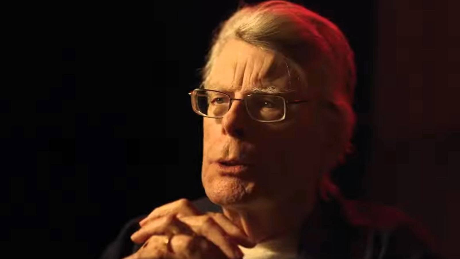 Stephen King talks with his hands clasped together
