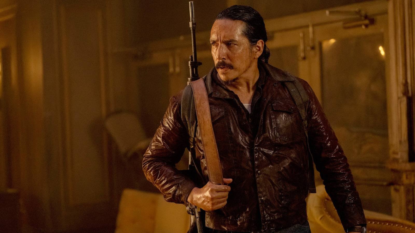 Gabriel Luna as Tommy holding a rifle on his back in HBO's The Last of Us