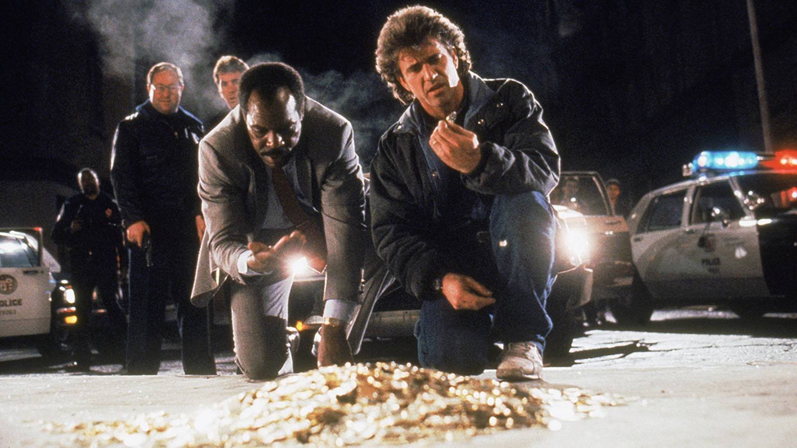 Riggs and Murtaugh investigating coins in Lethal Weapon 2