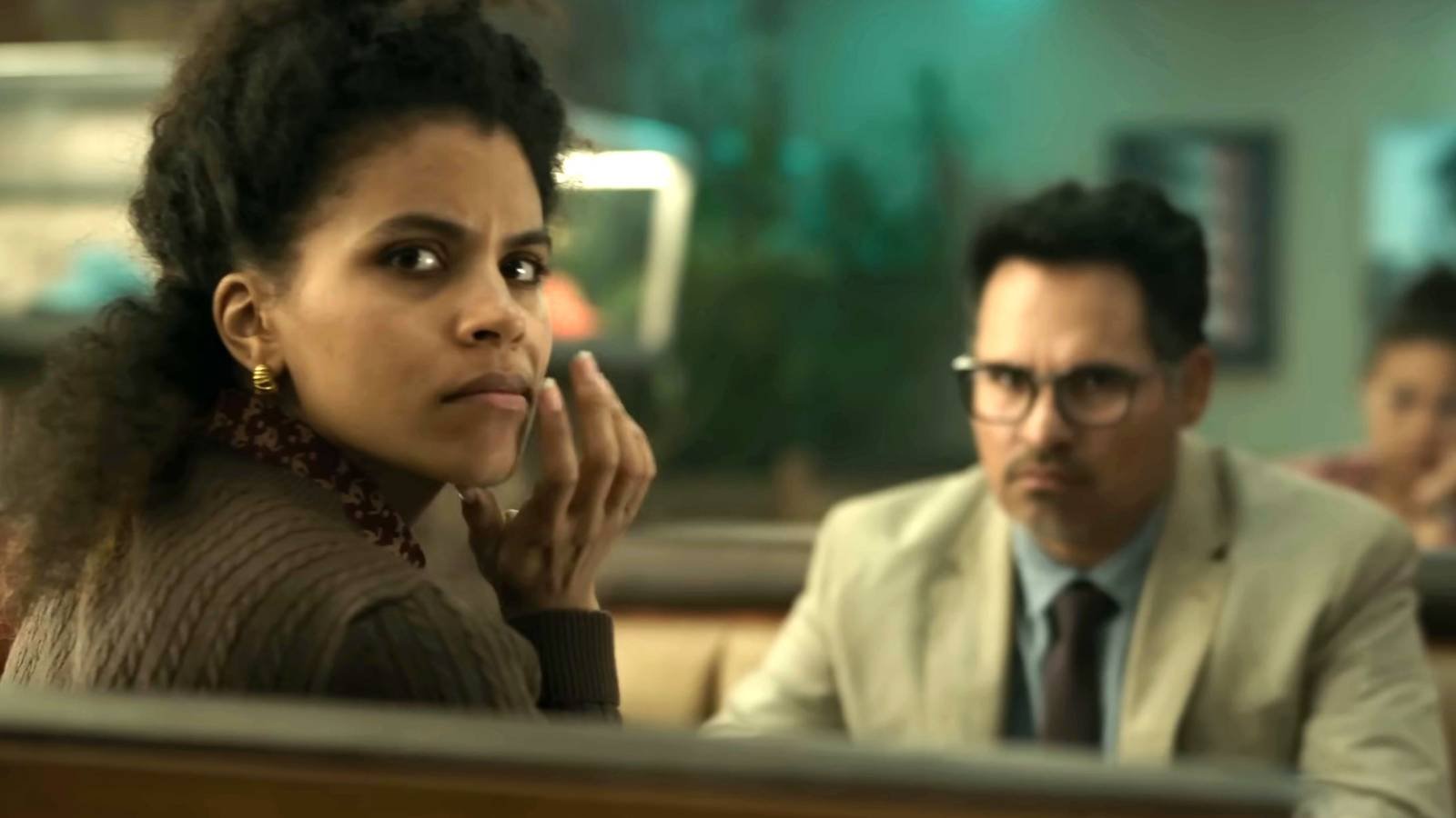 Zazie Beetz's Janet and Michael Peña's Mark looking intensely while in a diner booth in Good Lu...