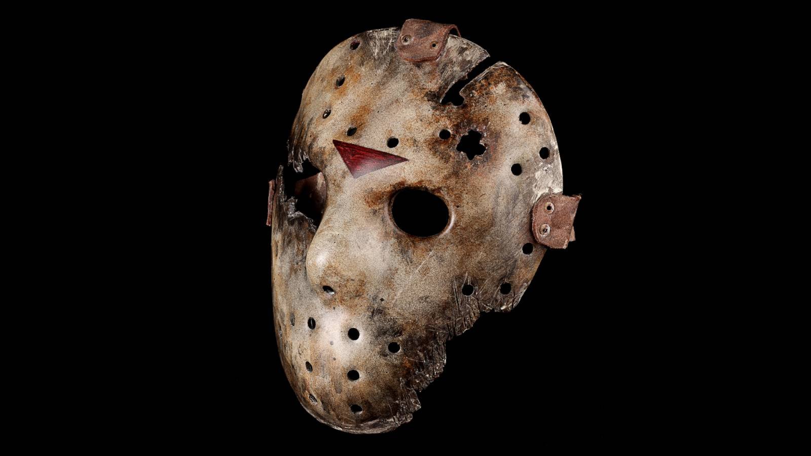 A prop Jason Voorheen mask photographed in front of a black background