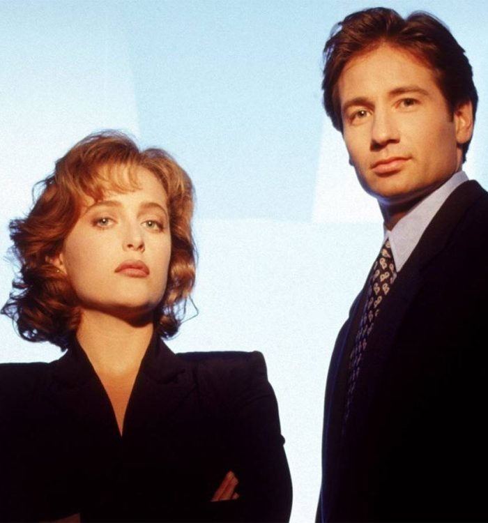 Gillian Anderson and David Duchovny standing together in a promo photo for the early seasons of T...
