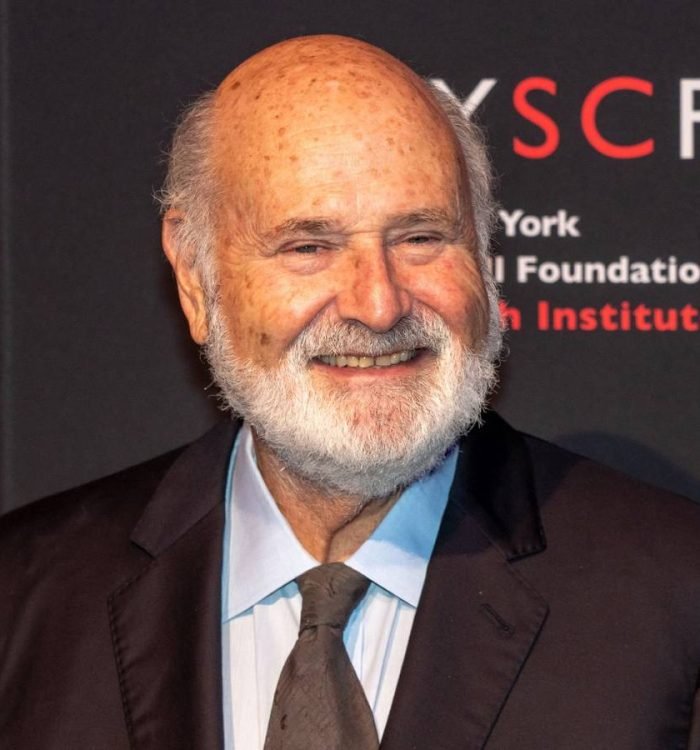 Rob Reiner smiles while standing on the red carpet